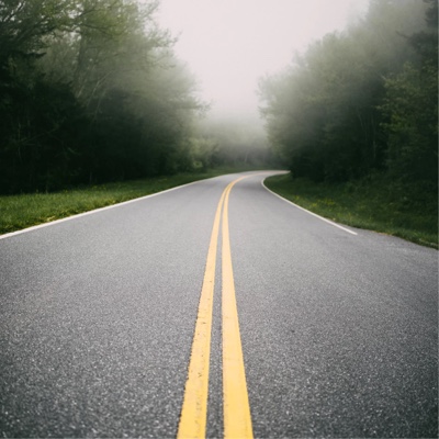 A curved, open road with trees on both sides