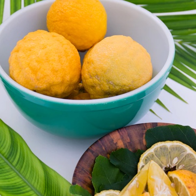 A bowl of lemons and a plate of sliced lemons