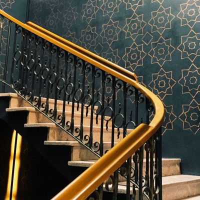 A staircase leading up with golden rails